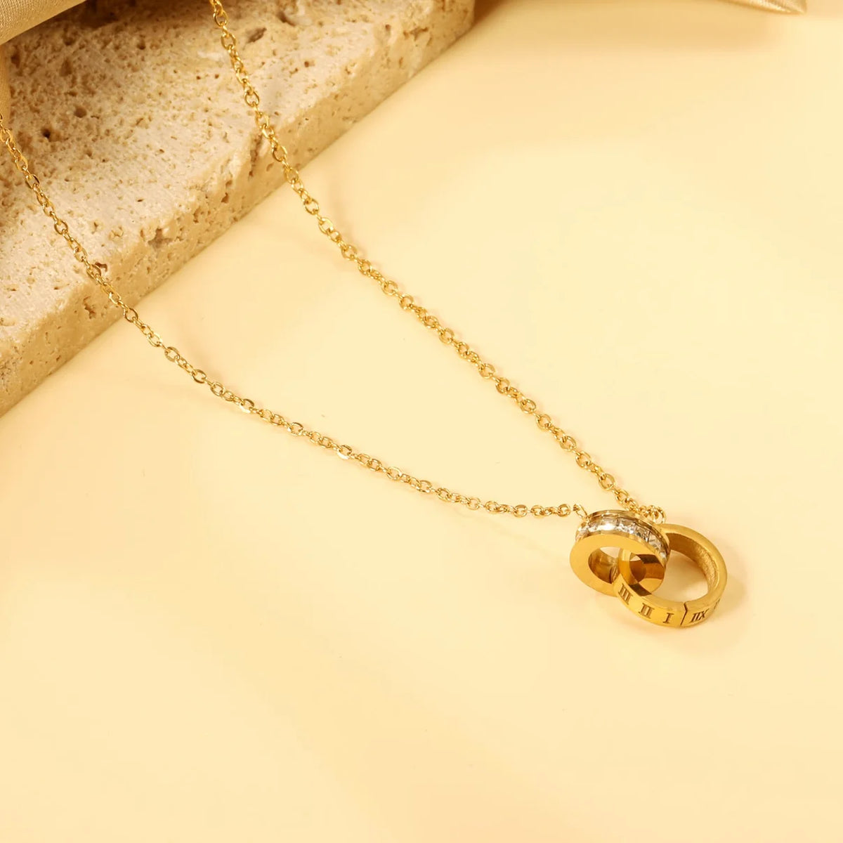 Collana dorata con doppio cerchio, zirconi e numeri romani